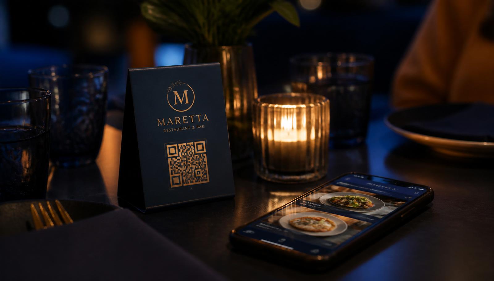 Restaurant table at night with a branded QR code table tent beside a phone showing the digital menu